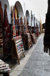 Image du Maroc Professionnelle de  Marchand de tapis à l'entrée du souk de Dlala des tapis et produits de l'artisanat marocain à la cité des Habous. Parmi les endroits les plus pittoresques de Casablanca, la Cité de Habous conçue par les architectes Auguste Cadet et Edmond Brion d’après l’ébauche d’un premier plan-masse dû à Albert Laprade. La construction n’avait commencé qu’après la première guerre mondiale. Situé près du Palais Royale, ce joyau architectural est le point de départ de la nouvelle médina de la ville, Vendredi 18 Novembre 2011. Le quartier des Habous fait partie du patrimoine architectural de Casablanca (Photo / Abdeljalil Bounhar)